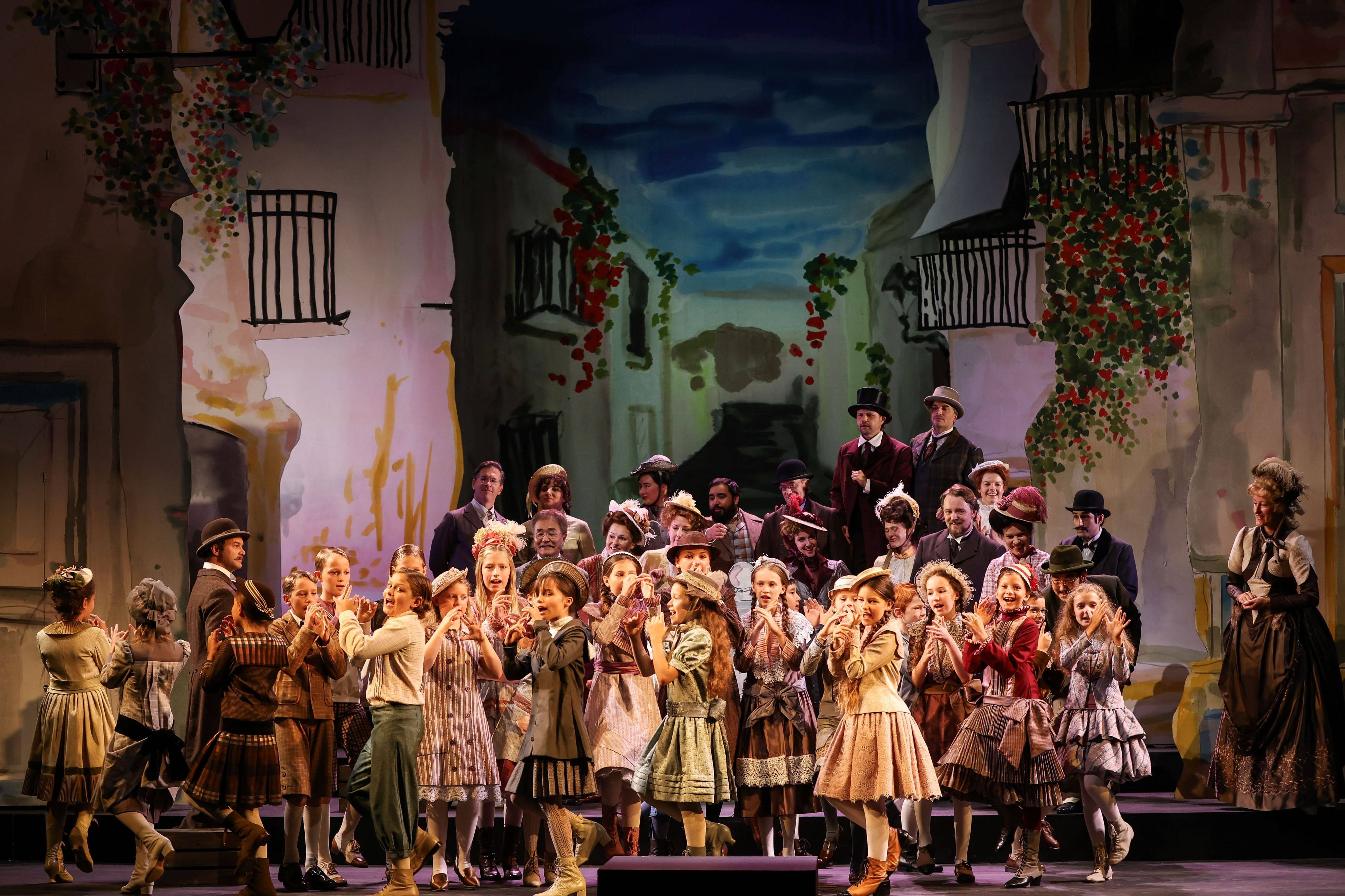 Children's choir singing on stage in front of a backdrop